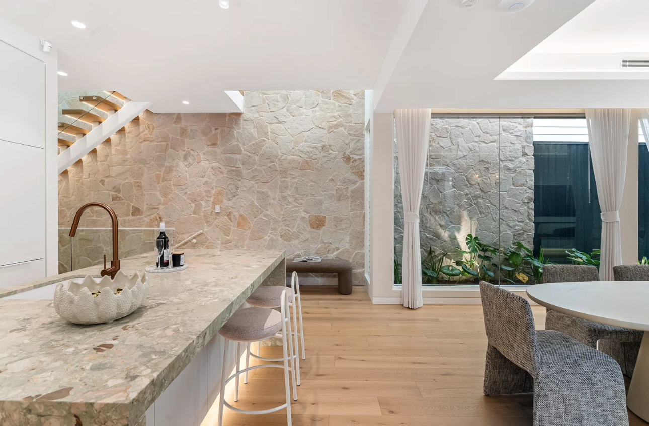 Natural stone benchtop and feature wall installed by Cinajus