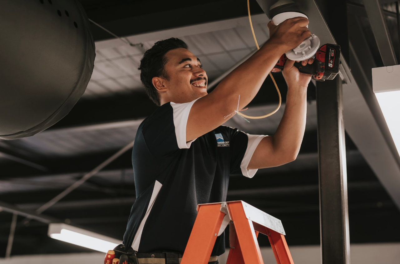Inside Out Security technician installing a security camera on-site