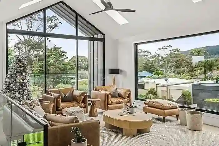 A living room in an NB Custom Builds home, floor-to-ceiling windows overlooking the Mornington Peninsula